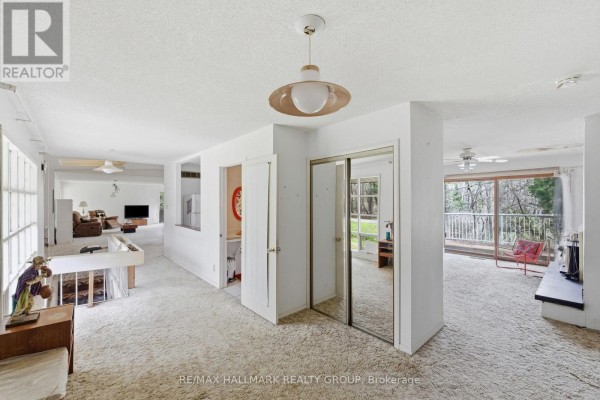 Interior hallway with plush beige carpet, mirrored closet doors, and views into living areas. - 111 Elmgrove Road, Drummond/north Elmsley