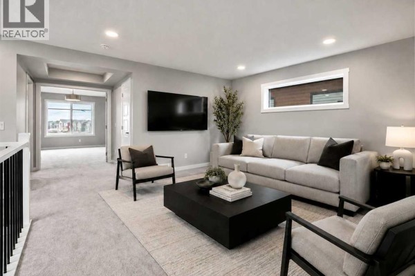 Living room featuring a sectional sofa, coffee table, fireplace, and view of a hallway. - 111 Heritage Ridge, Cochrane