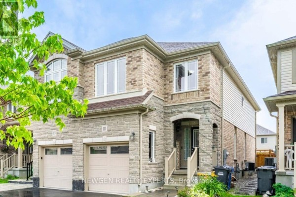 View of the side exterior of a two-story house with brick and stone facade and attached garage. - 111 John Brabson Crescent, Guelph