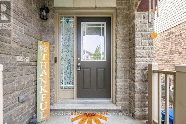 Front door with a frosted glass sidelight, stone entryway, and a 'Thankful' wooden sign. - 111 John Brabson Crescent, Guelph