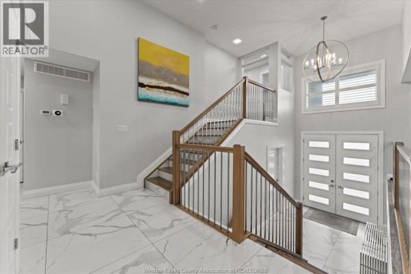 Open kitchen and dining area with modern appliances, marble flooring, and access to a deck. - 111 Lambert Street, Amherstburg