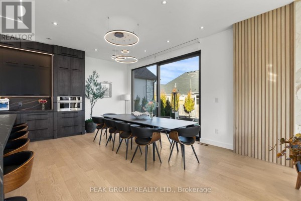 Modern bedroom with king platform bed, wood accent wall, large windows, and chandelier - 111 Millpond Road Niagara On The Lake