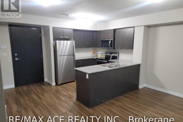 Modern kitchen with dark wood cabinets, stainless steel appliances, and a granite island. - 1110 - 2152 Lawrence Avenue E, Toronto