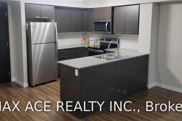 Kitchen area with dark cabinets, stainless steel fridge, and a central island with sink. - 1110 - 2152 Lawrence Avenue E, Toronto