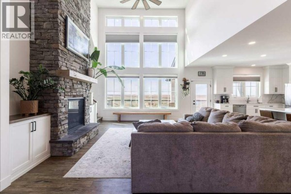 Living room with a floor-to-ceiling stone fireplace, vaulted ceilings, large windows, and a sectional sofa. - 111072 Rr#151, Purple Springs