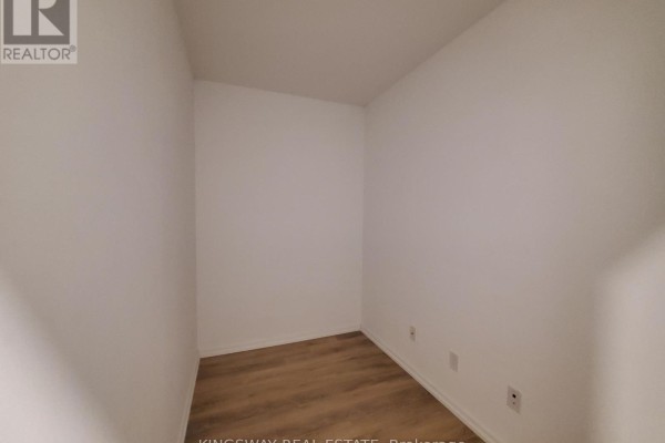 Small empty room with white walls and light brown laminate flooring. - 1111 - 197 Yonge Street, Toronto