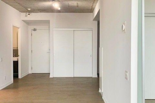 Hallway with a closet, doors to rooms, and hardwood floors in an open-concept apartment. - 1111 - 318 King Street E, Toronto