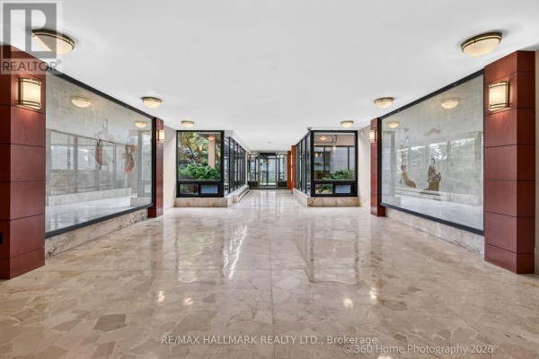 Interior hallway with marble floors, glass panels, and decorative artwork on walls. - 1111 - 360 Ridelle Avenue, Toronto