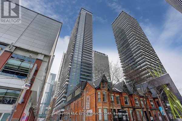 Street view of modern high-rise apartment buildings in Toronto with a Victorian house in front. - 1111 - 38 Widmer Street, Toronto