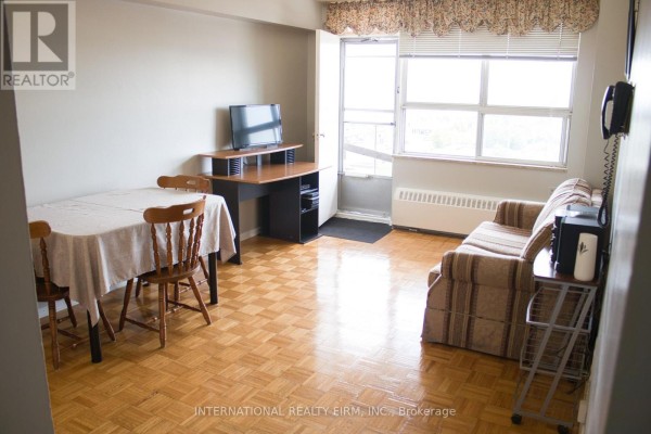 Living and dining area with sofa, table, chairs, desk, and TV. - 1111 - 50 Lotherton Pathway, Toronto