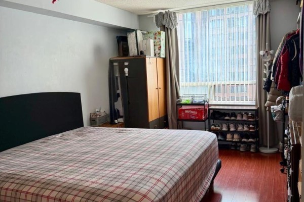 Bedroom with a queen-size bed, wardrobe, shoe rack, and window with grey curtains. - 1111 - 633 Bay Street, Toronto