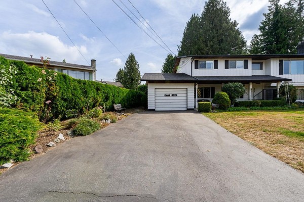 View of the driveway leading to the attached garage of a white two-story house. - 11142 Patricia Drive Drive, Delta