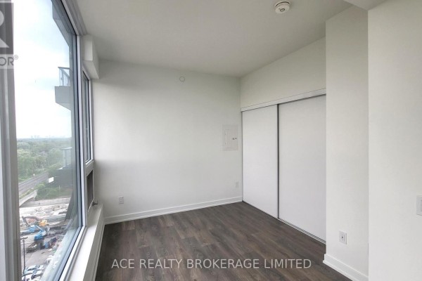 Bedroom with floor-to-ceiling windows, dark wood flooring, and white sliding closet doors. - 1116 - 28 Ann Street, Mississauga