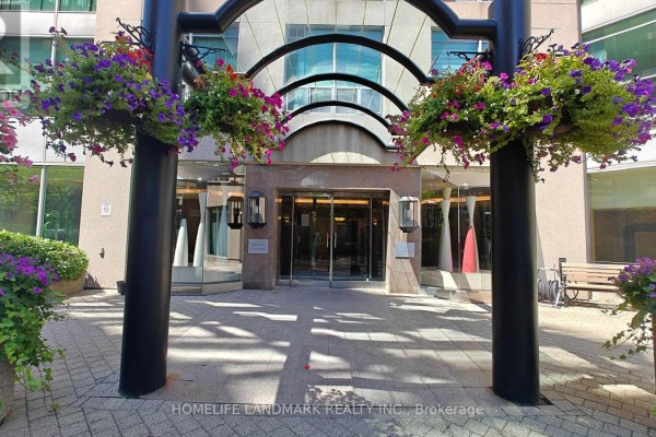 Entrance to the building with a glass archway and hanging flower baskets. - 1116 - 942 Yonge Street, Toronto