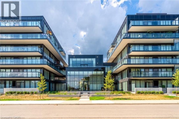 Exterior view of a modern apartment building with two wings connected by a glass-covered entryway. - 1117 Cooke Boulevard Unit# A305, Burlington