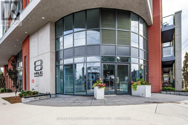 Close-up of the building's entrance with large glass windows and "8 HAUS" signage. - 112 - 2433 Dufferin Street, Toronto