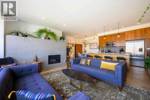 Open concept living room, dining area, and kitchen with fireplace. - 112 21 Street Nw, Calgary