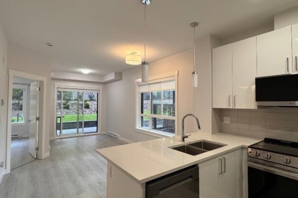 Kitchen with island and living area with patio doors and a window. - 112 33886 Pine, Abbotsford