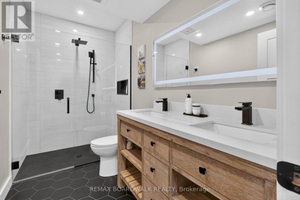 Modern double vanity bathroom with walk-in shower, LED mirror, and black fixtures - 112 Argile Street Casselman