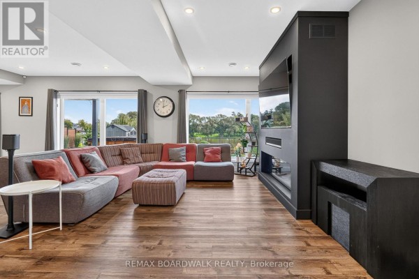 Living room with sectional sofa, fireplace, TV, and water view - 112 Argile Street Casselman
