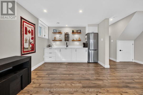 Wet bar with stainless steel refrigerator and white cabinets - 112 Argile Street Casselman
