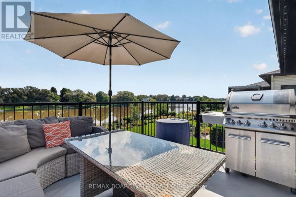 Deck patio with outdoor seating, grill, and water view - 112 Argile Street Casselman