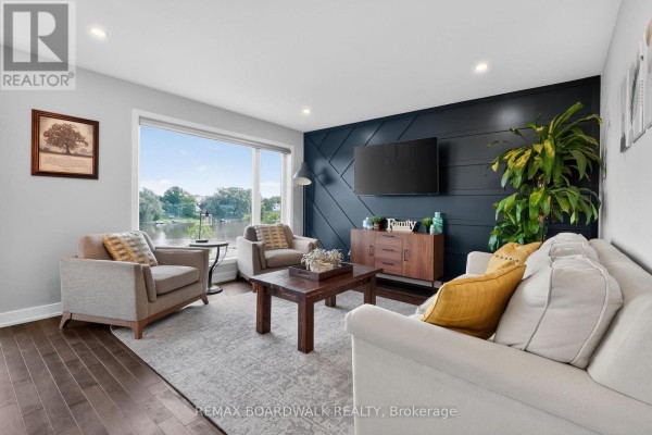 Living room with water view, accent wall & furniture - 112 Argile Street Casselman