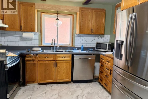 Kitchen with light wood cabinets, stainless steel appliances, and white subway tile backsplash. - 112 Arthur Street, Brantford