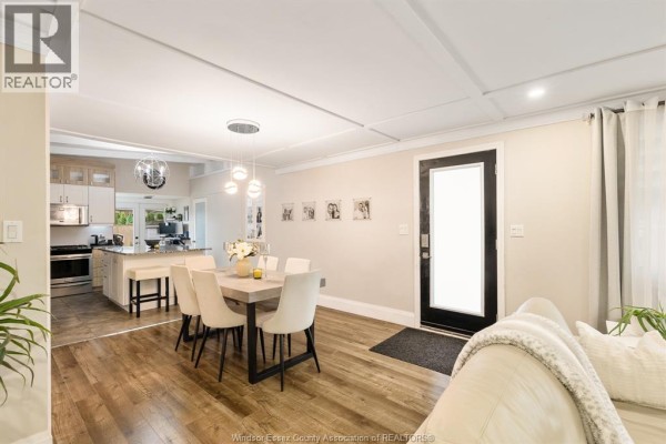 Dining area with a table and chairs, connected to a kitchen with an island and stainless steel appliances. - 112 Clovelly, Tecumseh