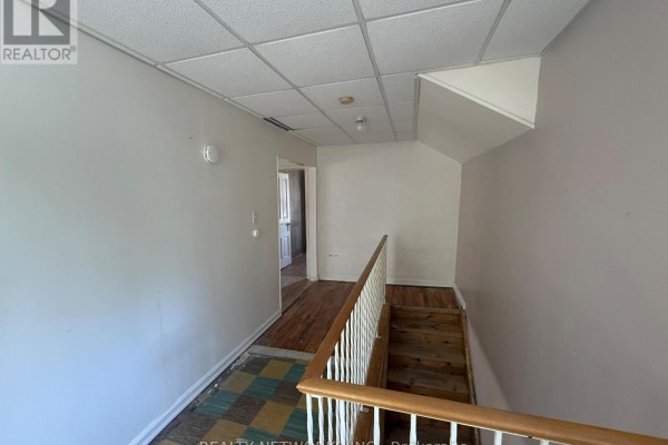 Hallway with hardwood floors, a tiled area, and a staircase. - 112 Dwyer Avenue, Timmins