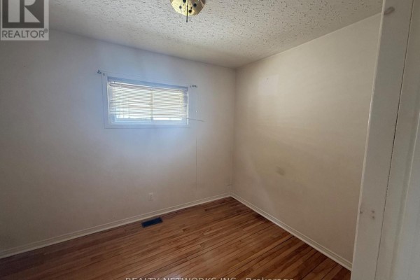 Bedroom with hardwood floors, white walls, and a window with blinds. - 112 Dwyer Avenue, Timmins