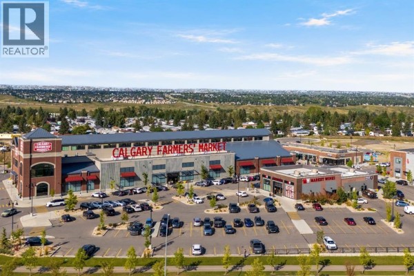 Exterior view of the Calgary Farmers' Market building with a large parking lot. - 112 Greenwich Drive Nw, Calgary