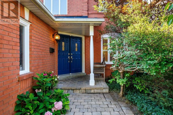 Close-up view of the front entrance with a blue double door, brick facade, and paved walkway. - 112 Mulholland Drive, Vaughan