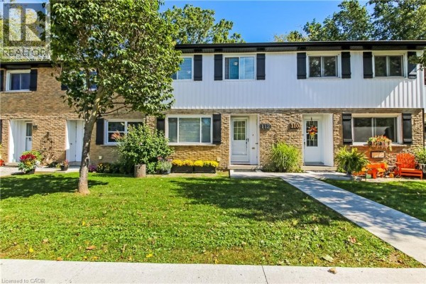 Front exterior view of a townhouse with brick and white siding, black shutters, and a green lawn. - 112 Richardson Drive Unit# 24, Port Dover