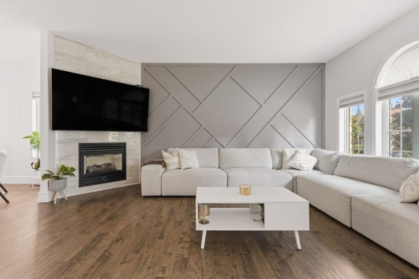 Living room featuring a gas fireplace, wall-mounted TV, and a decorative geometric wall panel. - 112 Rue D'outremont, Gatineau