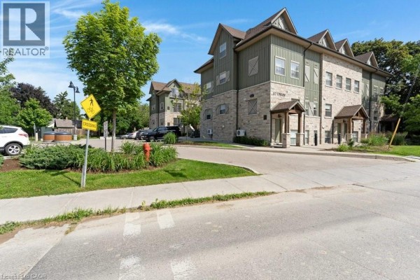 Street view showing the entrance to 112 Union Street E Unit# B103 with traffic signs and trees. - 112 Union Street E Unit# B103, Waterloo