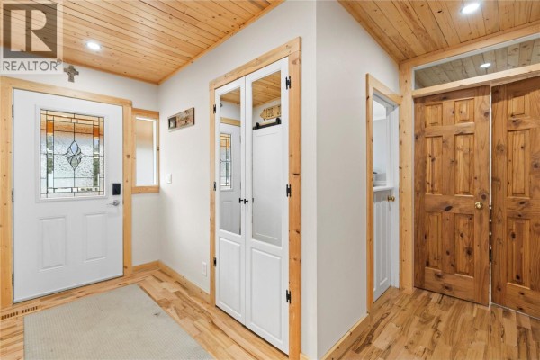 Entryway with wooden paneling, closet space, and a decorative glass door. - 112 Walker Road, Clearwater