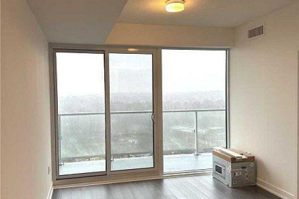 Living area with large glass sliding doors leading to a balcony and a view of the surroundings. - 1120 - 20 O'neill Road, Toronto