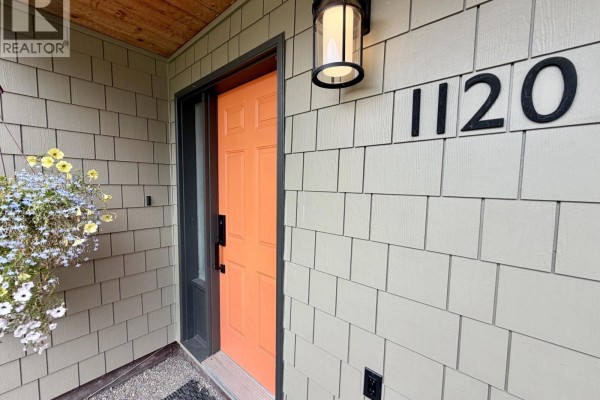 Close-up of the orange front door with house number 1120 above. - 1120 Toronto Street, Smithers