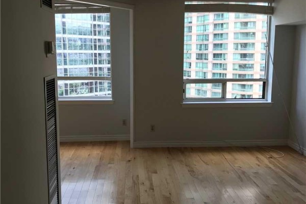 Interior view of a room with light gray walls and large windows. - 1122 - 633 Bay Street, Toronto
