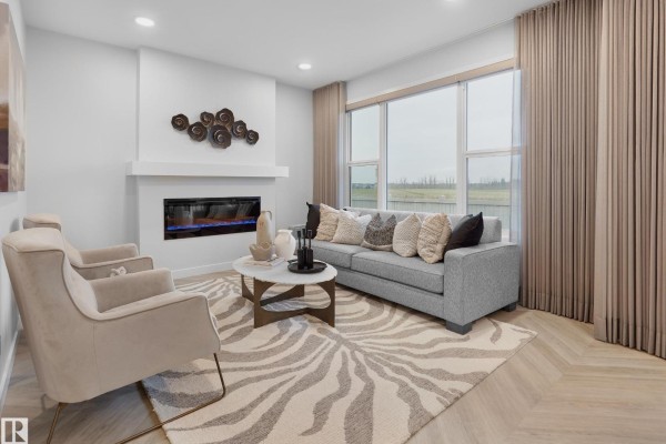 Living room with a gray sofa, two armchairs, fireplace, coffee table, and large window. - 1124 Cristall Cr Sw, Edmonton