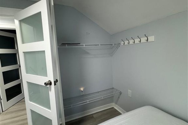 Interior closet space with white wire shelving and hooks against pale blue walls. - 1124 Janette Avenue Unit# Room Lvl 2, Windsor