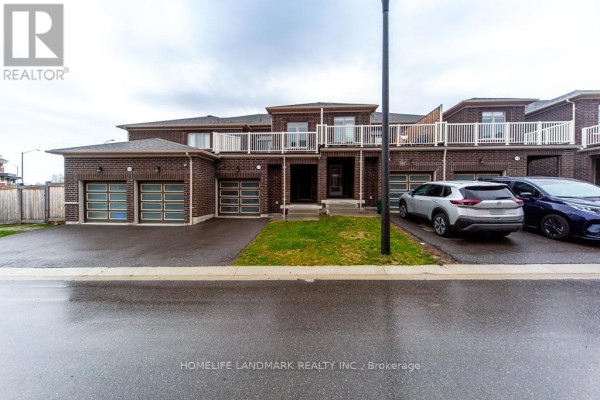 Front view of the brick townhouse complex with multiple garage doors and parked cars. - 1126 Baltic Lane, Pickering