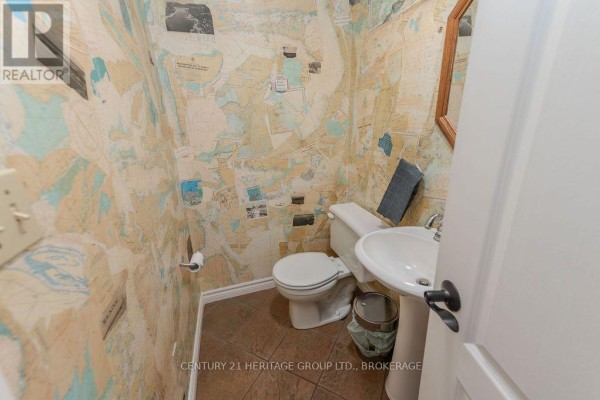 Powder room with map wallpaper, toilet, and pedestal sink - 1127 Perry Lane Frontenac