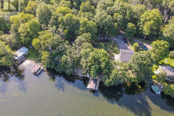 Lakefront property with docks, boats, and trees - 1127 Perry Lane Frontenac