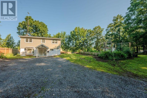 Two-story house with gravel driveway and garden - 1127 Perry Lane Frontenac