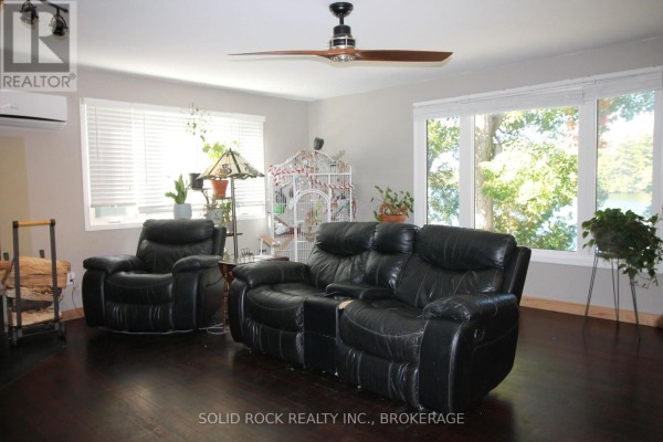 Kitchen with light wood cabinets, granite countertops, stainless steel appliances, and a large island with dark wood base. - 1127 Perry Lane, Frontenac