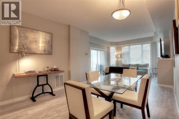 View of dining area and living room with large windows and sofa. - 1128 Sunset Drive Unit# 706 Lot# 52, Kelowna