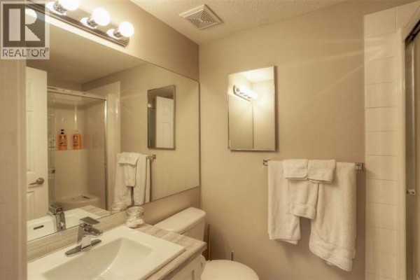 Bathroom vanity with sink, mirror, towels, and a shower stall. - 1128 Sunset Drive Unit# 706 Lot# 52, Kelowna