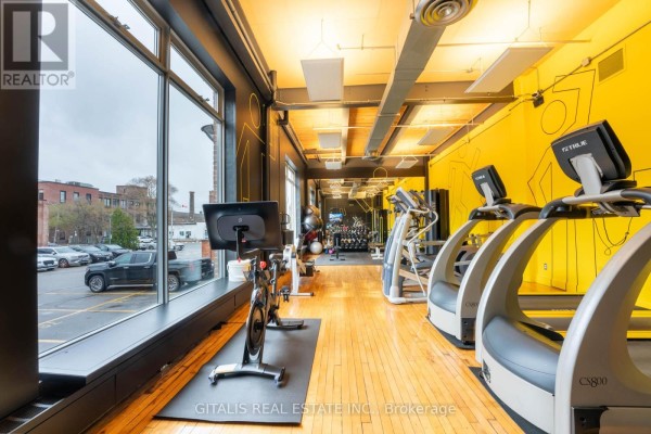 Gym with treadmills, stationary bikes, and large windows overlooking parking lot. - 112c - 219 Dufferin Street, Toronto